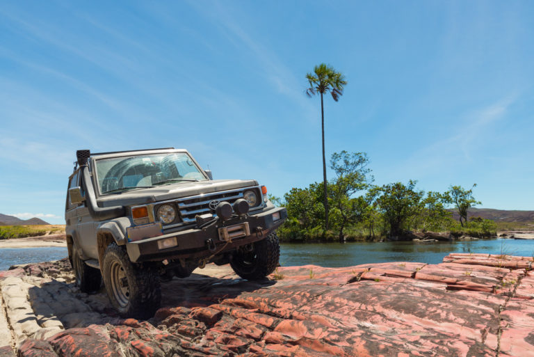 Classic Toyota LandCruiser parked next to a remote river | Driveline Services Australia