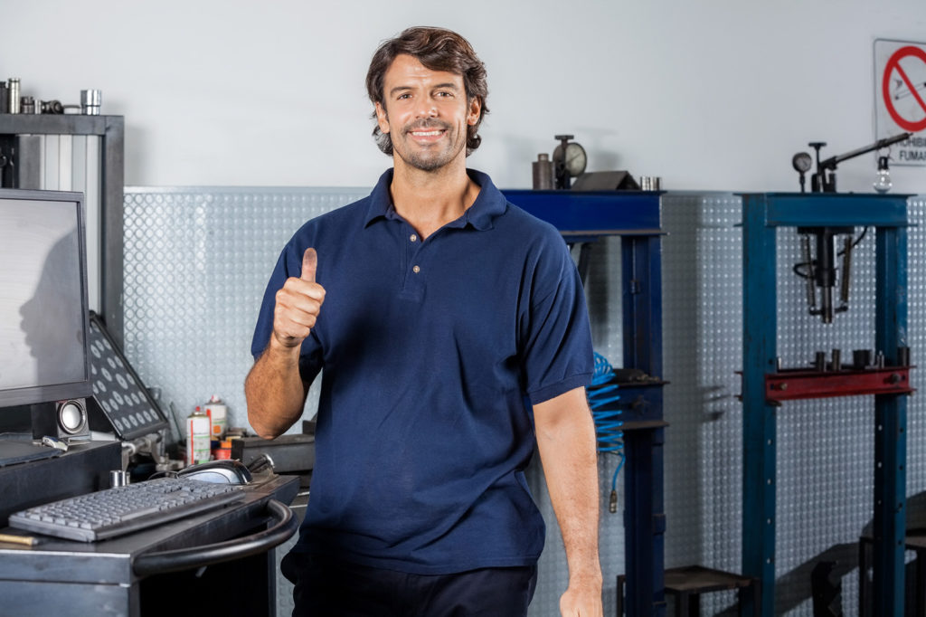 Mechanic standing at a computer terminal giving the thumbs up | Driveline Services Australia