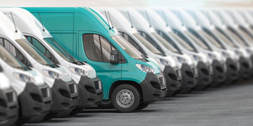 Green delivery van parked in a row of white delivery vans | Driveline Services Australia